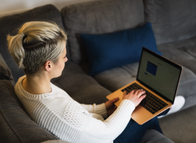 Kvinde i sofa med laptop online undervisning